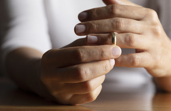 Hands of caucasian female who is about to taking off her wedding ring.